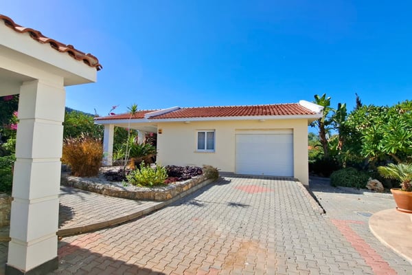 Single-storey guest annex and landscaped drop-off zone with box shrubs, creating a formal yet easy-to-maintain entrance.
