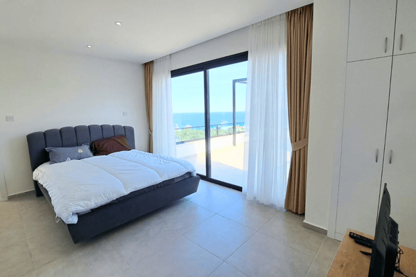 Bedroom with built-in closet and balcony view, blending practicality with light-filled tranquility.