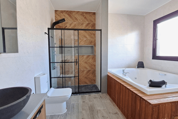Spa-inspired bathroom with a jacuzzi tub, soft natural light, and wood accents.