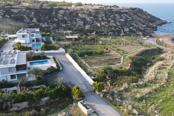 Contemporary beachfront villa in Northern Cyprus with a spacious terrace, open design, and expansive ocean-facing glass windows.