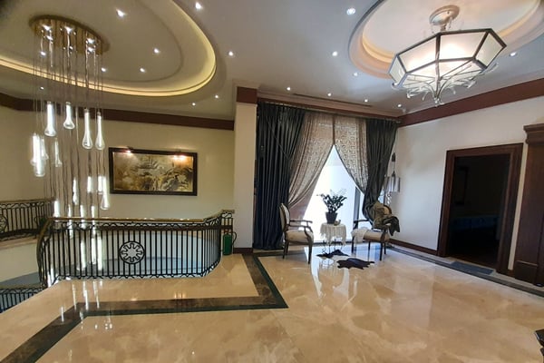 Modern Bathroom with Double Vanity and Elegant Fixtures – A chic bathroom or dressing space featuring a double vanity, mirrored cabinetry, tiled flooring, stone countertops, and modern or ornate fixtures.