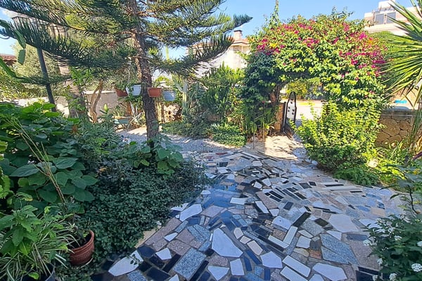 Spacious outdoor barbecue area with a rustic wooden dining table, perfect for alfresco gatherings.