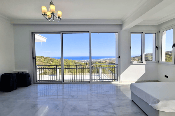Spacious bedroom with large sliding doors to a balcony.
