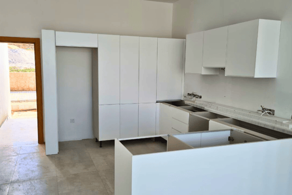 Minimalist kitchen with integrated appliances and white finishes, offering functionality wrapped in sleek modern design.