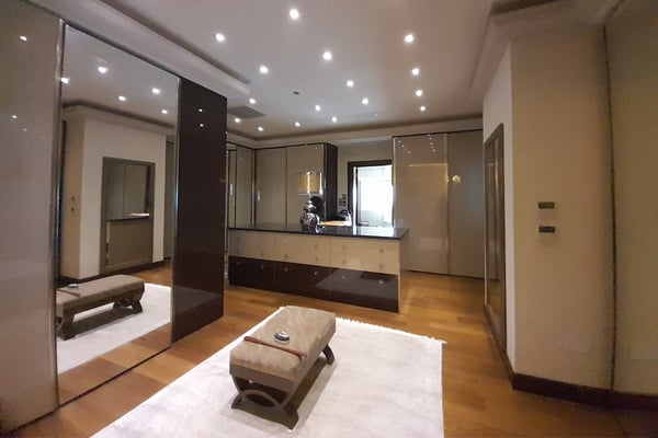 Elegant Foyer with High Ceilings and Decorative Accents – A beautifully designed hallway or foyer featuring a stylish console table, high ceilings with intricate molding, and a polished floor leading to other rooms.