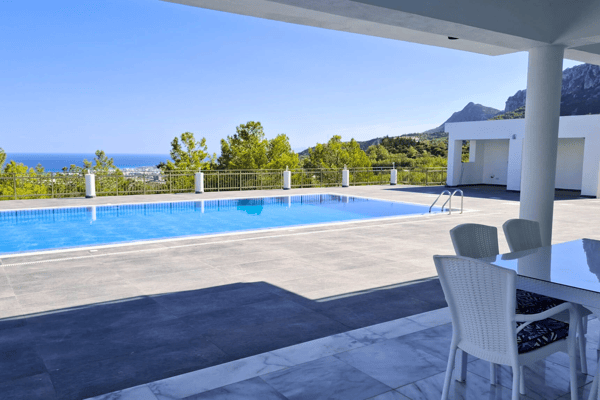 Pool and patio view extending to the horizon; white pillars frame the space.