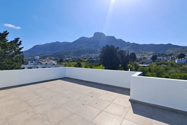Panoramic mountain backdrop visible from the rooftop, offering tranquil natural surroundings.