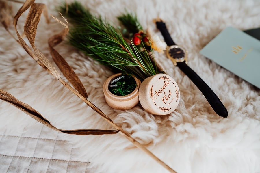 Wedding rings in box with watch on fur rug