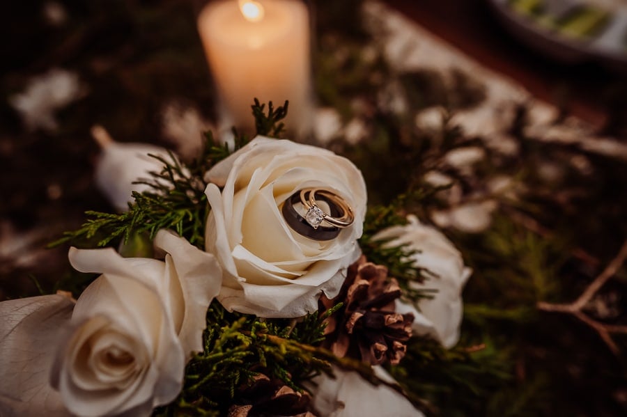 Wedding rings sitting together on bouquet rose