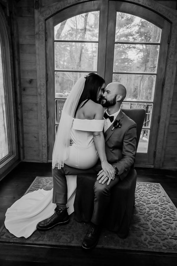 Bride sitting on grooms lap kissing