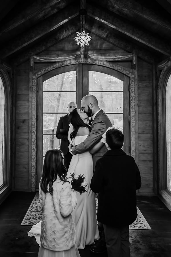 Bride and groom kissing at wedding ceremony indoor