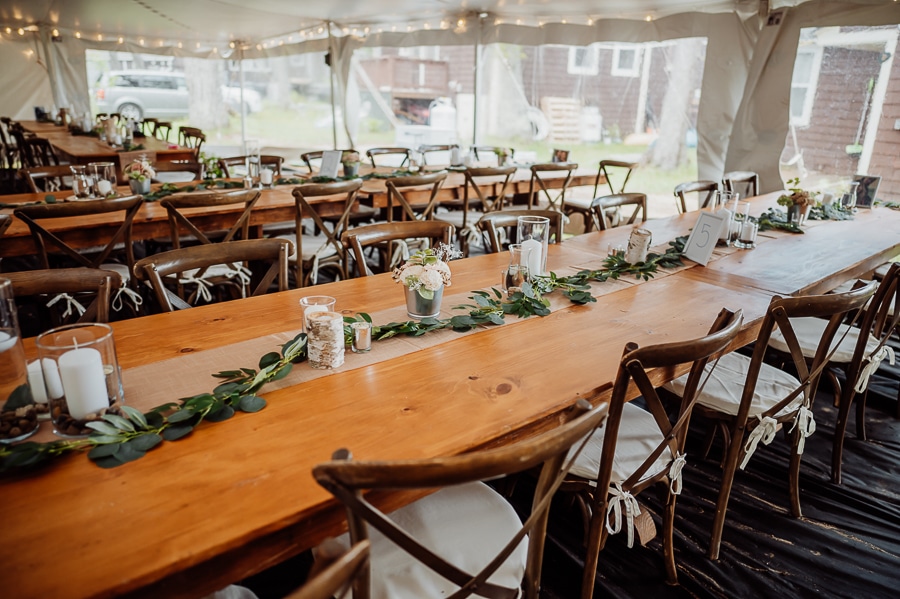 Tables decorated under tent at wedding