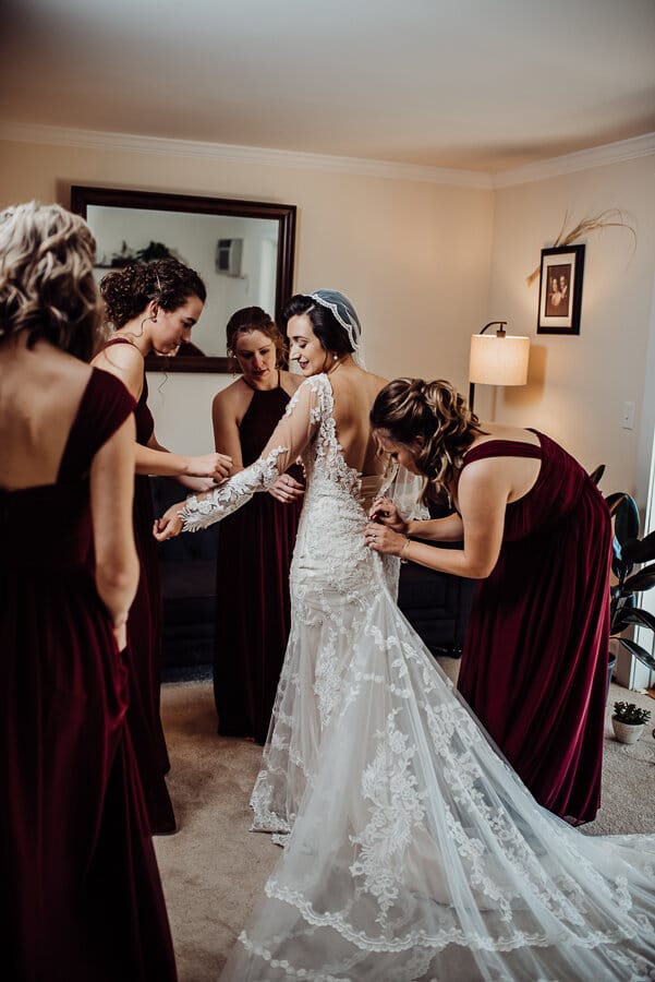 Bridesmaids fixing wedding dress
