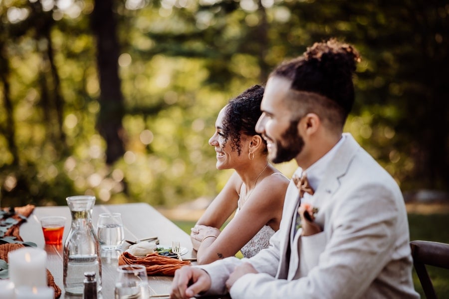 Bride and groom smiling with bride in focus at head table