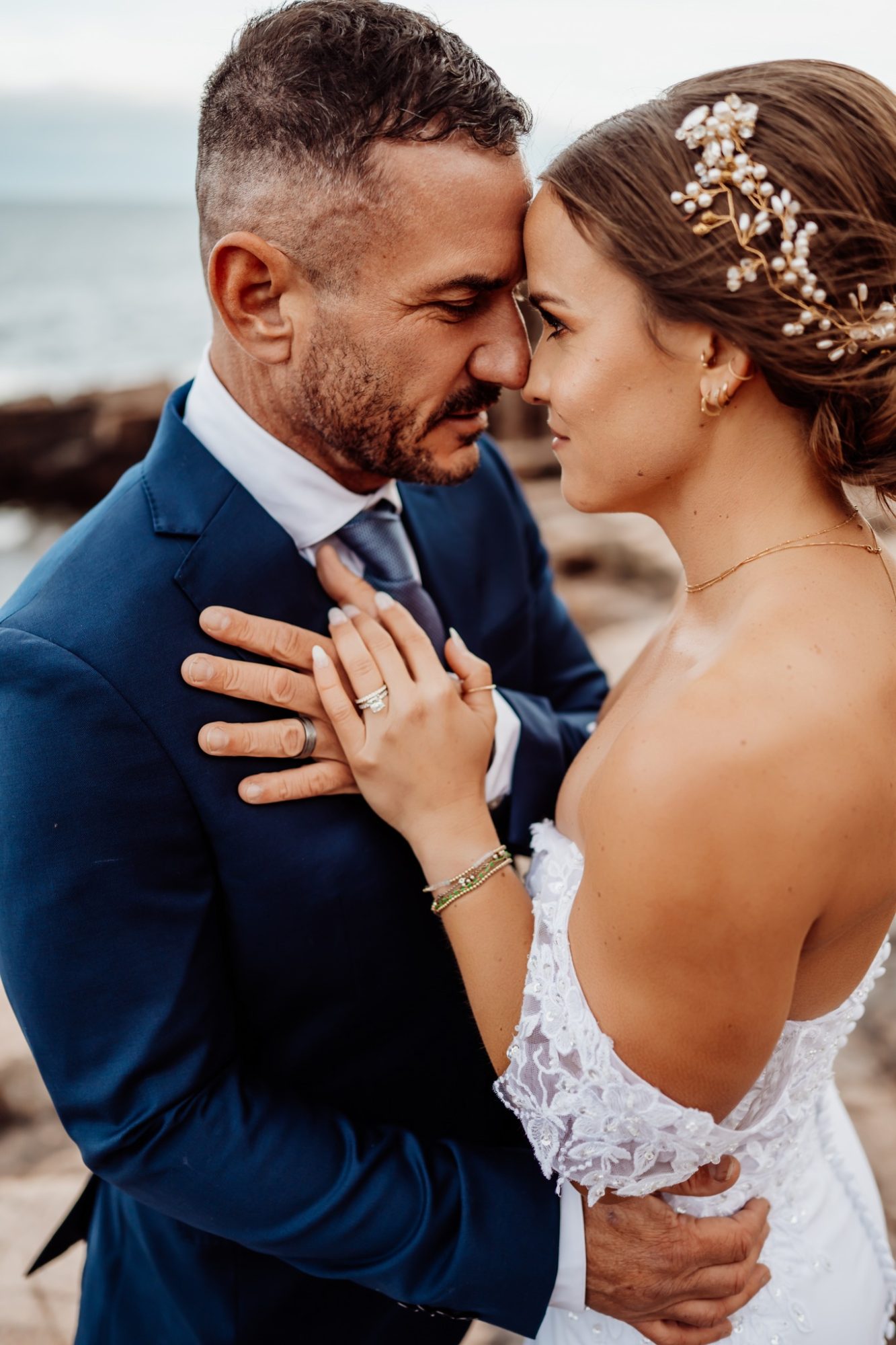 Close-up of bride and groom touching foreheads during their Acadia National Park elopement on the rocky Maine coastline.