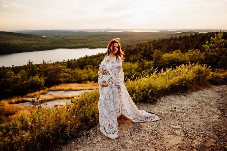 Woman posing for maternity photos on cadillac mountain