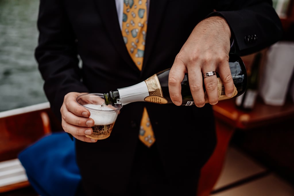 Groom pouring champagne into a cup