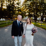 Bride and groom looking at each other laughing and walking in front of Bar Harbor inn