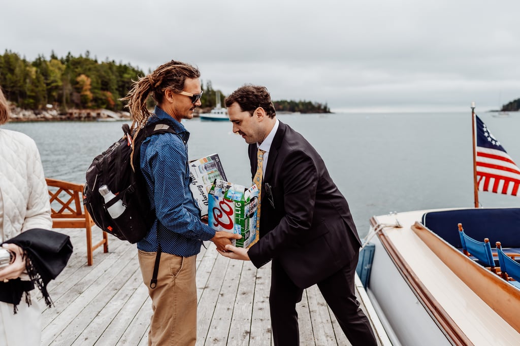 Man passing boxes of beers to groom on dock