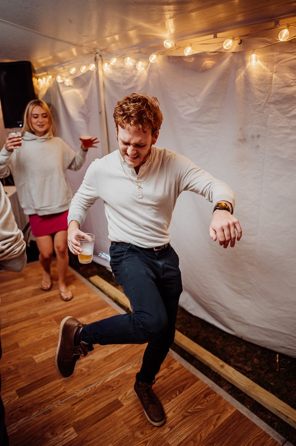 man with red hair and white shirt dancing at wedding