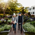 Woman and man wearing vests, plaid and hats walking in bar harbor garden