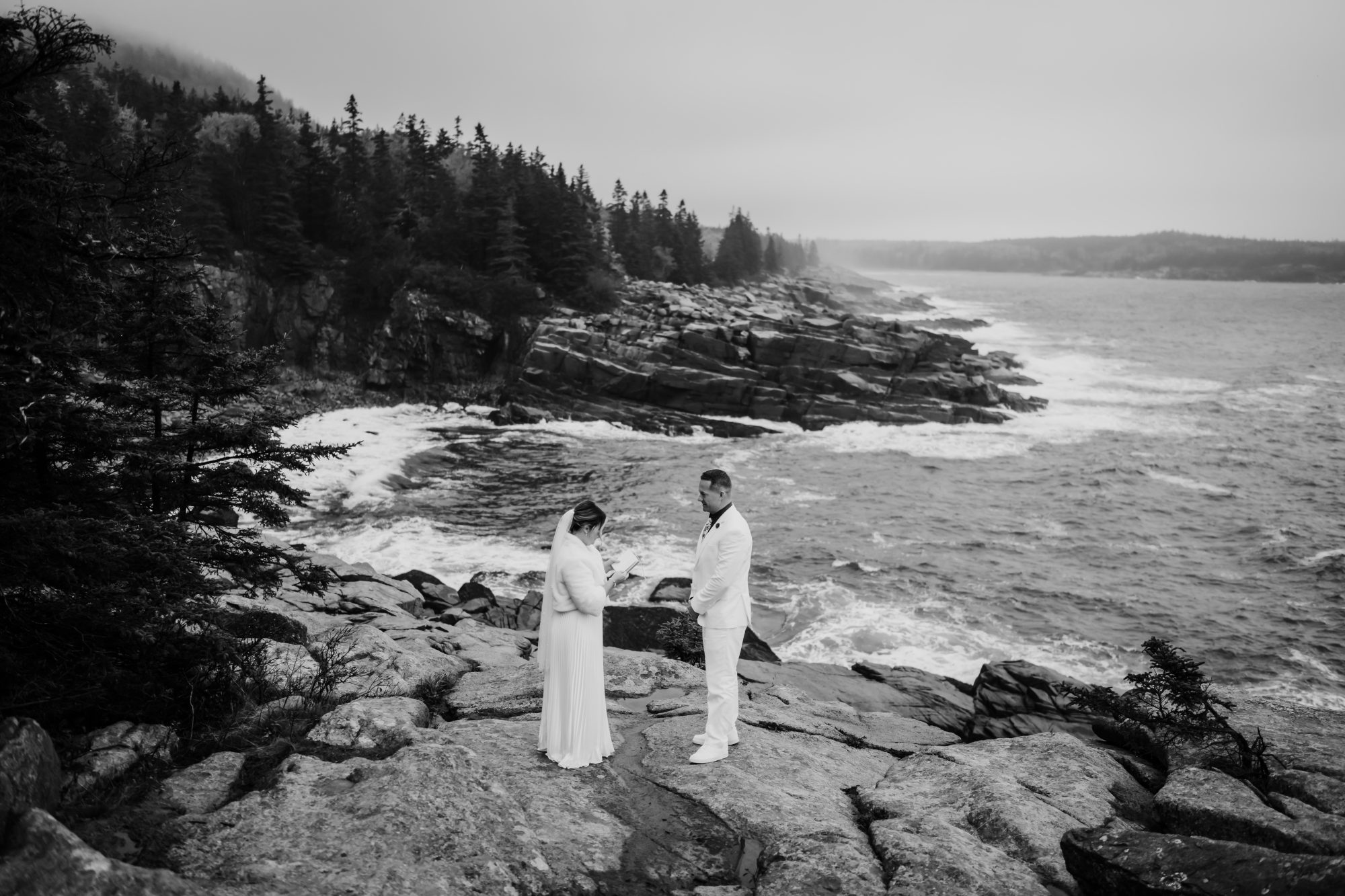 Black and white coastal portrait of couple at Thunder Hole in Acadia National Park.