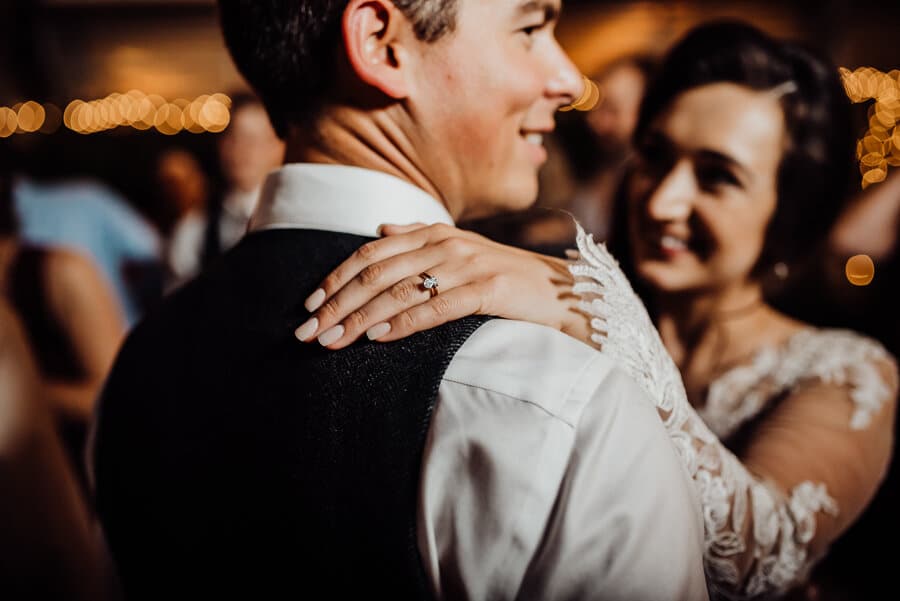 Brides hand on grooms shoulder at wedding