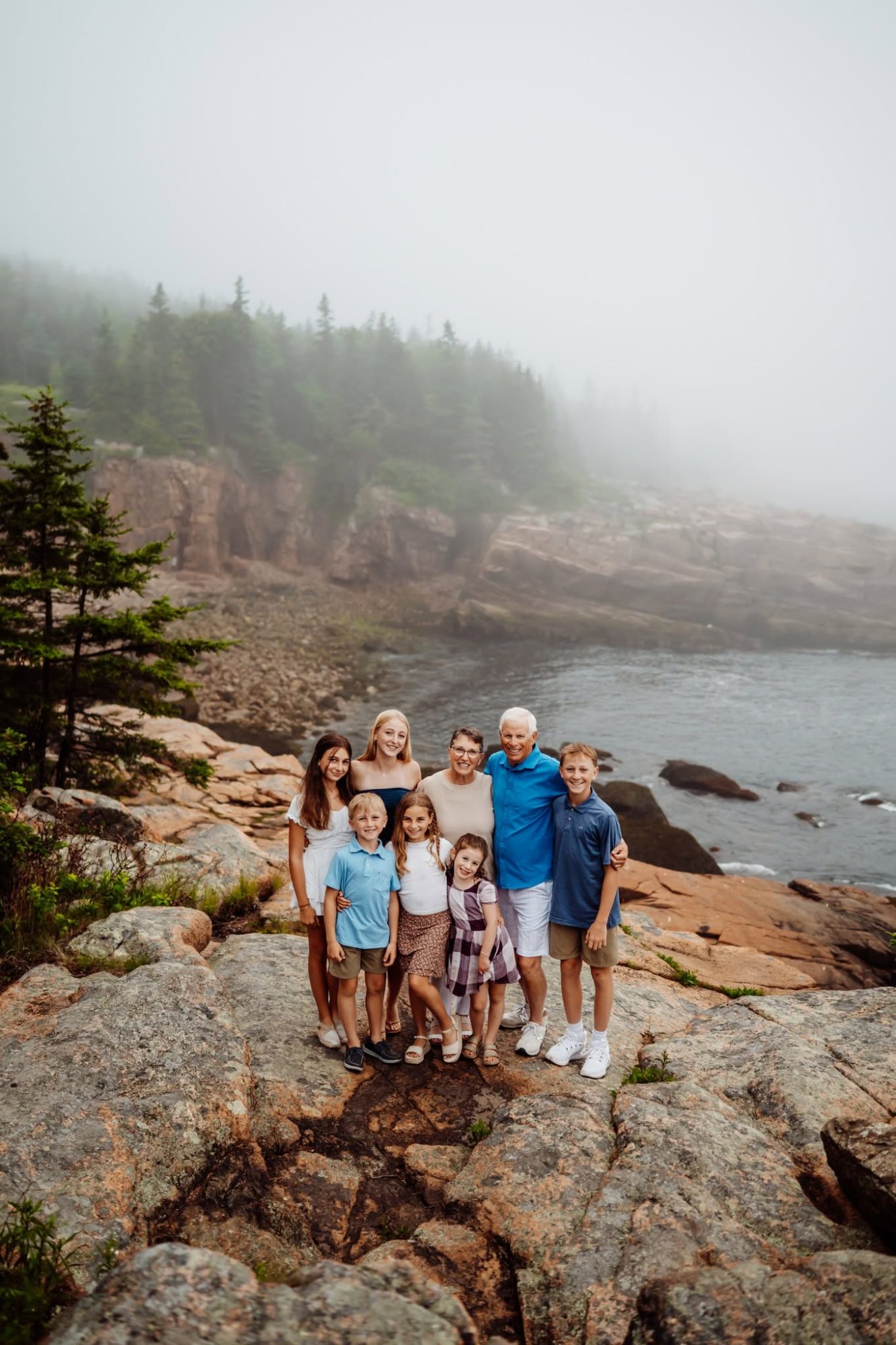 Family in fog at monument cove in acadia