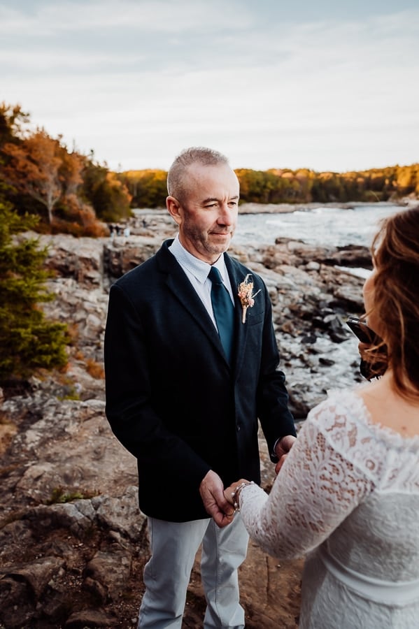 Groom smiling at bride during allotment ceremony at Schoodic overlook