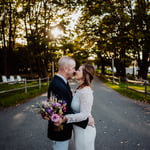 Bride and groom facing nose to nose in front of trees at Bar Harbor inn