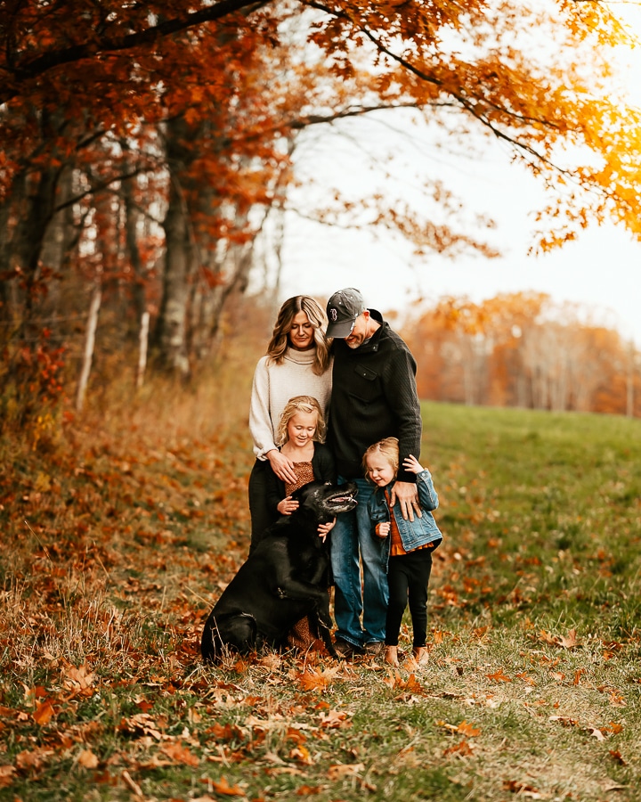 Family of 4 and black dog pose for family photos