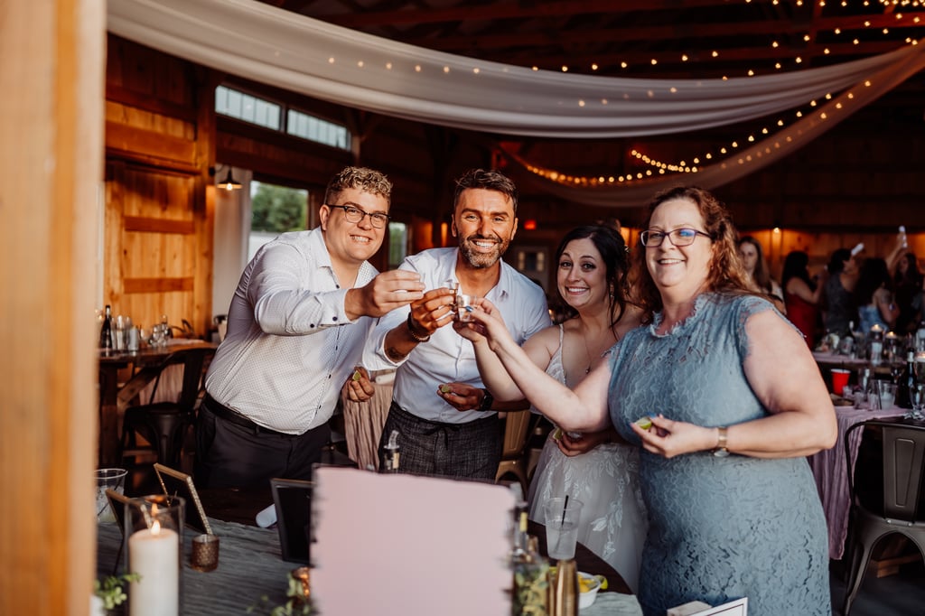 Bride and wedding guests having a cheers shot