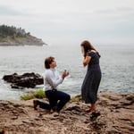 Man proposes to girlfriend on one knee by the ocean