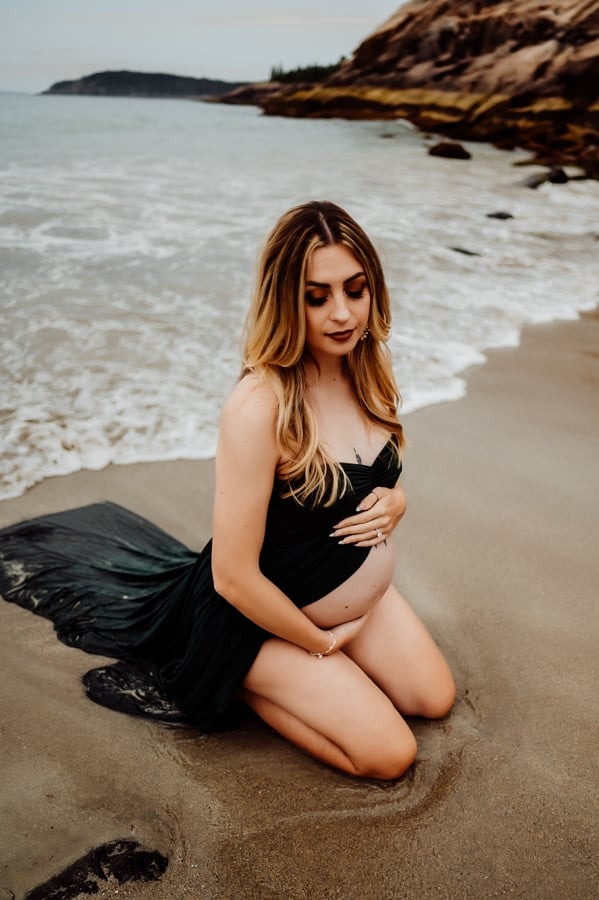 Woman wearing green dress maternity on the sand beach