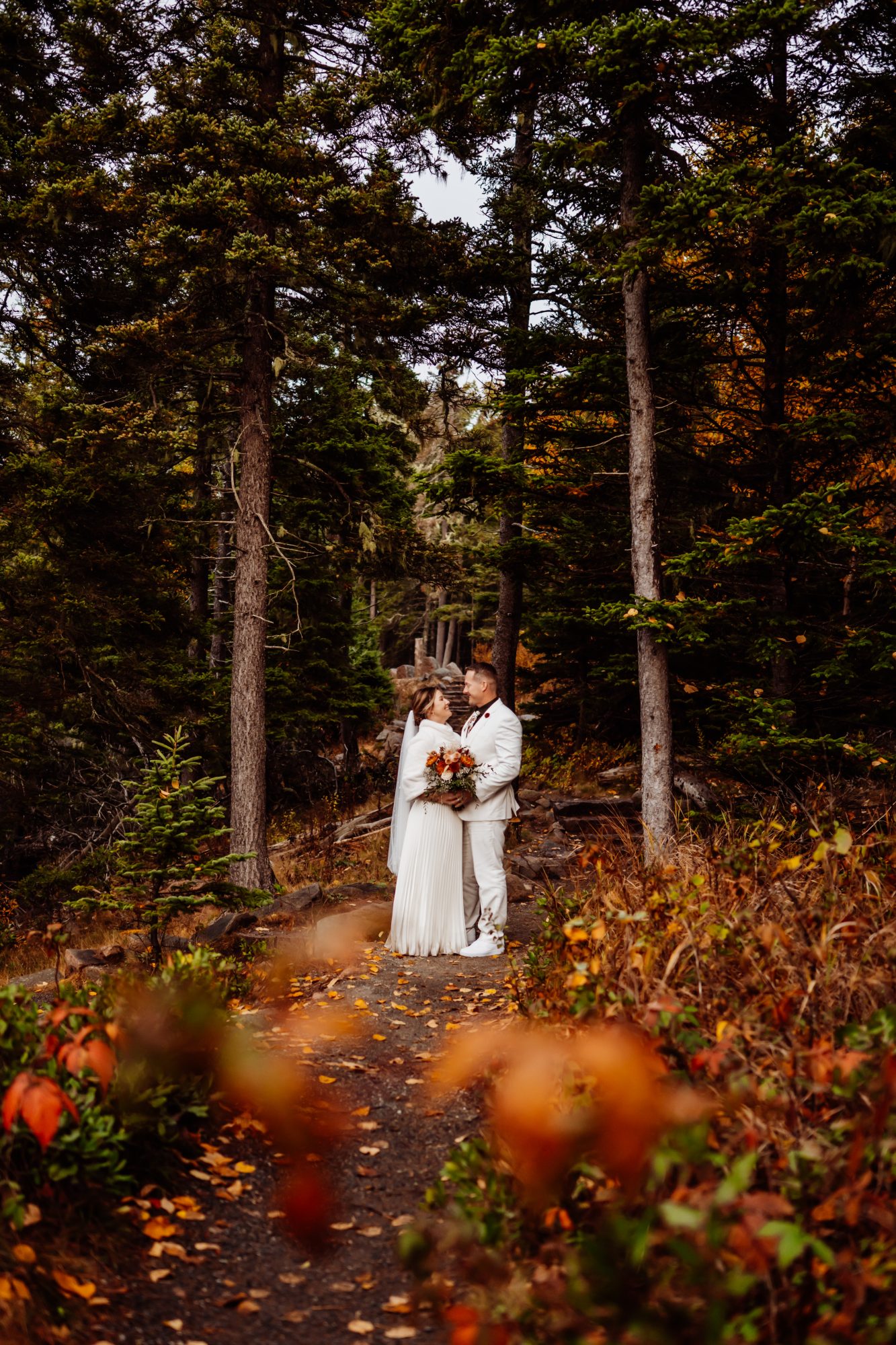 bride and groom framed by fall foliage during Acadia National Park elopement.