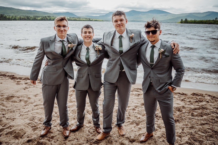 Groomsmen at wedding posing for photographer by lake