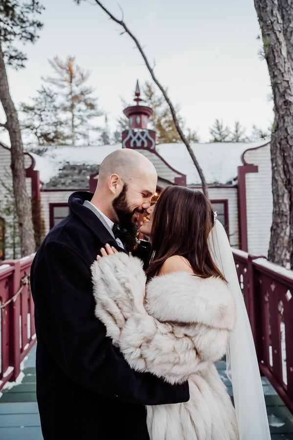Bride and groom kissing in front of castle house