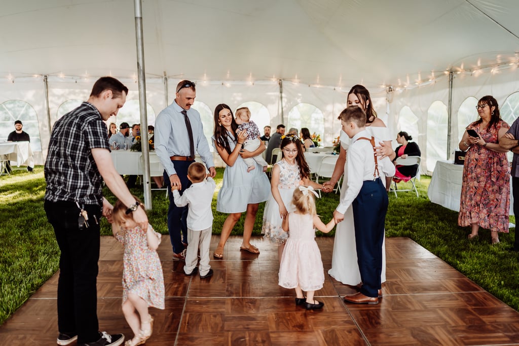 Wedding guests, including children, dancing together.
