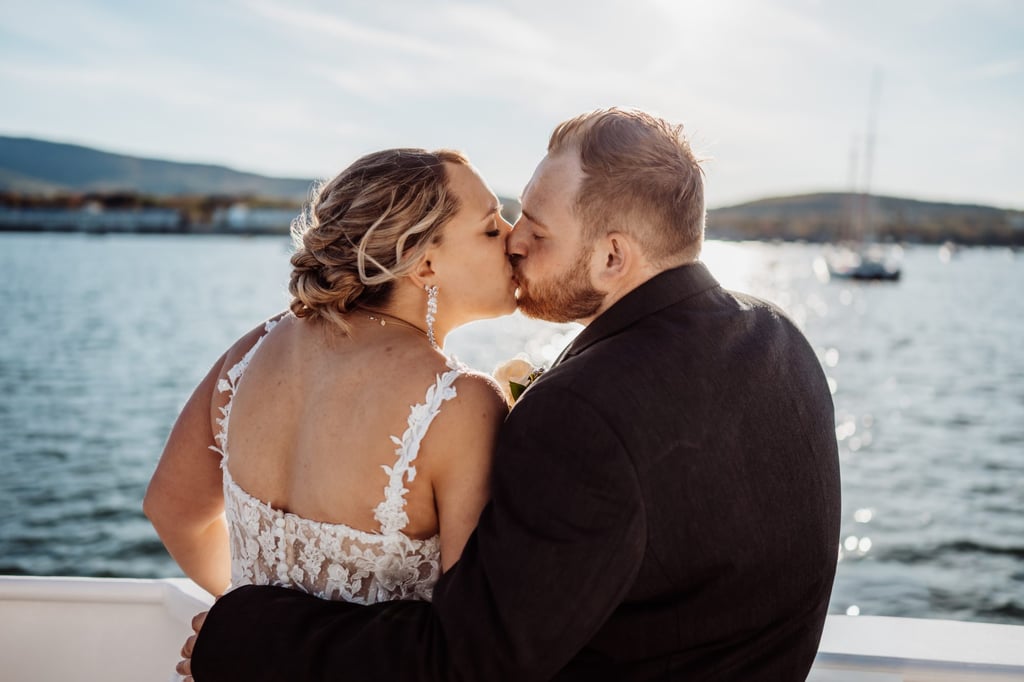 Bride and groom sharing a kiss on the deck of a charter boat during their Bar Harbor sunset cruise wedding celebration.