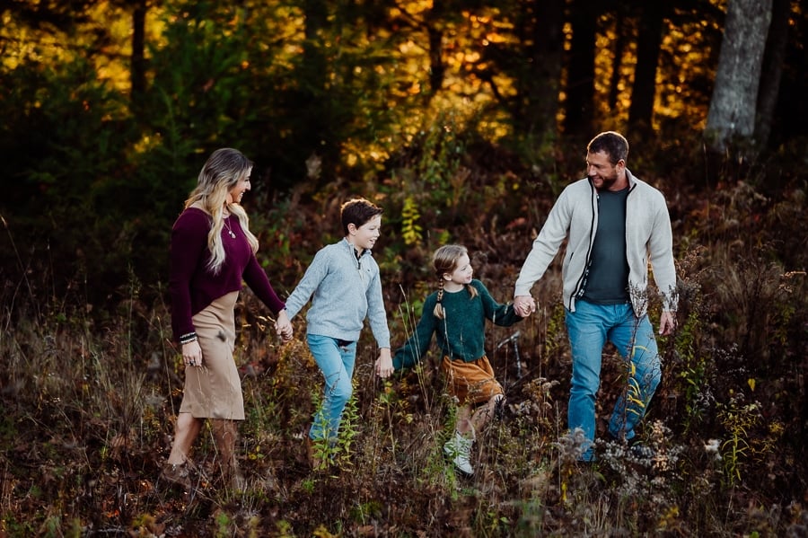 Family of four walking together in the woods