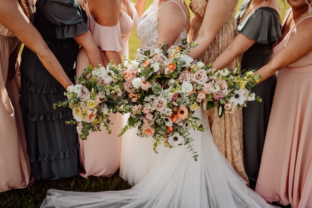 bridemaids and bride holding flowers together in the center