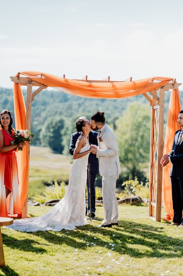 Bride and groom kissing at alter at clarks cove farm inn