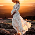Woman in white dress with brown florals holding belly on cadillac mountain at sunset