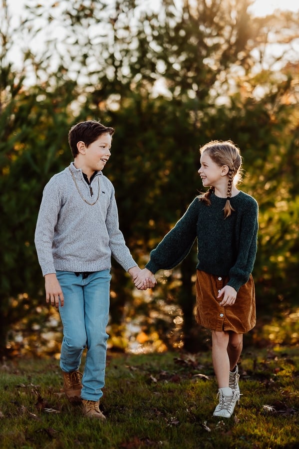 Boy and girl holding hands and looking at each other walking