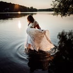 Pregnant woman wearing lace dress in Maine lake