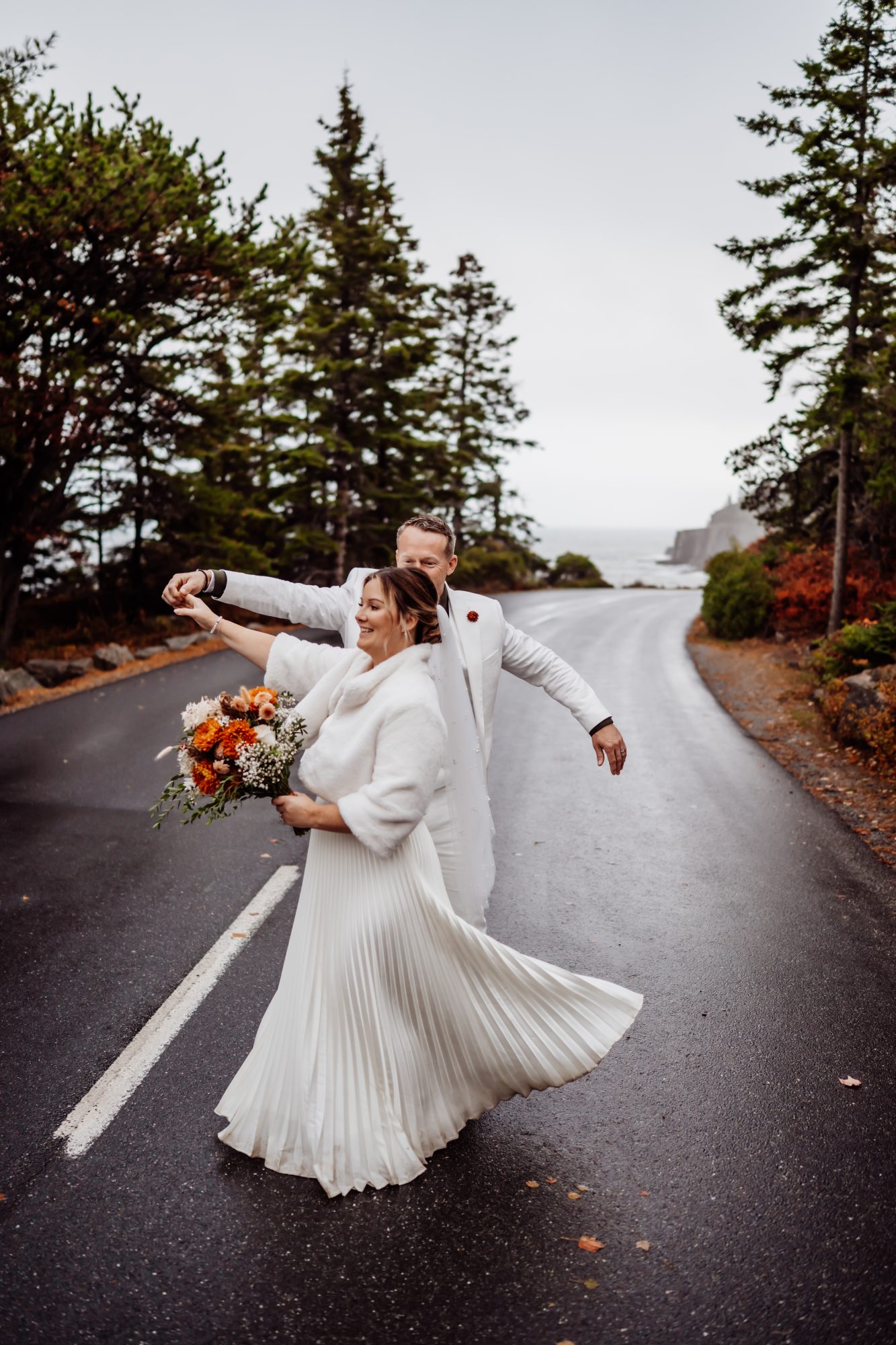 Bride twirling in the road during fall elopement in Acadia National Park