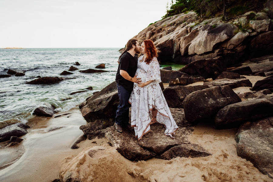 Bar harbor couple posing for maternity photos on sand beach