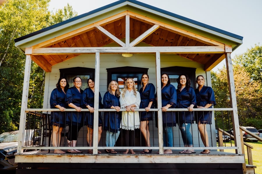Bride and bridesmaids on porch of cabin in skowhegan