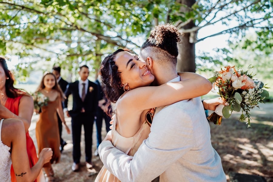 Woman hugging groom after wedding ceremony
