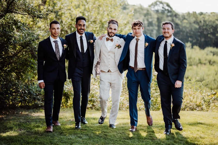 Groom with groomsmen walking together at walpole maine wedding